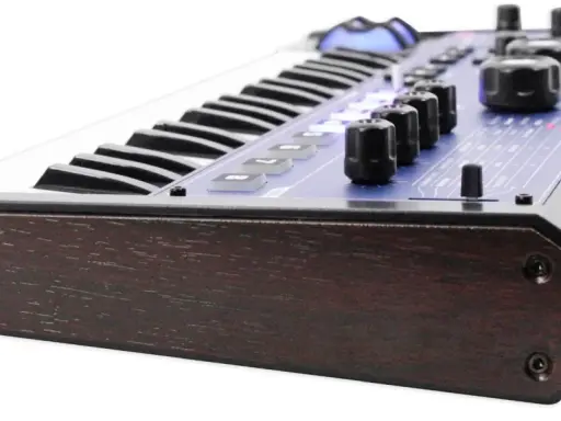 Clavier synthétiseur mini nova avec finitions bois sombre et panneau bleu lumineux.
