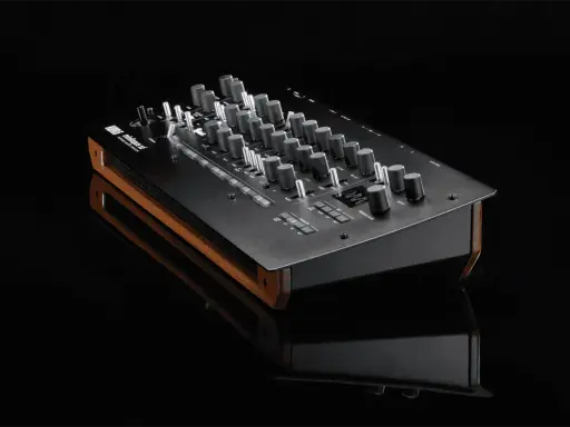 Synthétiseur Korg minilogue xd noir avec finitions bois, posé sur une surface réfléchissante.