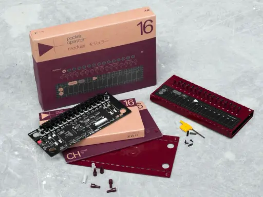Le **pocket operator** modular 16, son circuit imprimé et sa boîte sur fond gris. Un appareil pour créer de la musique.