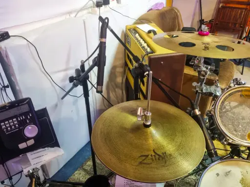 Un micro est positionné pour capter le son d'une batterie acoustique, prêt à enregistrer le rythme.