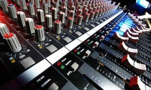 Console de mixage audio, avec ses potentiomètres et faders, prête pour le mastering gratuit.