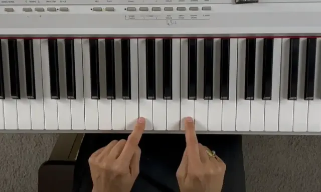 Deux doigts jouent un accord de piano.