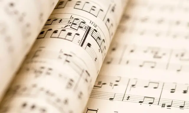 Partitions musicales ouvertes, révélant les nuances de la musique. Les notes et les portées se déploient, invitant à l'interprétation.