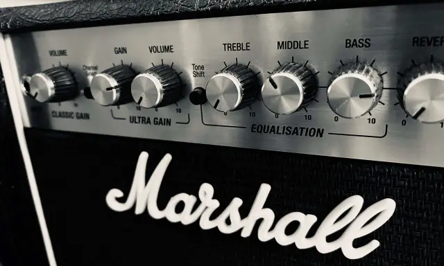 Gros plan sur le panneau de contrôle d'un ampli Marshall, avec les réglages de volume, gain, égalisation (treble, middle, bass) et reverb. Parfait pour le réglage ampli guitare acoustique.