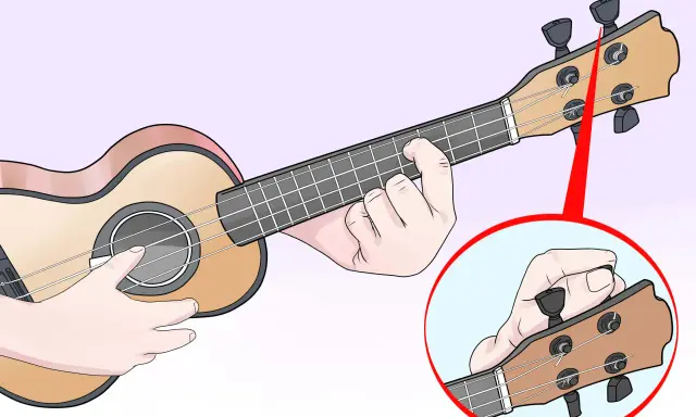 Main gauche sur le manche, main droite sur la tête pour accorder l'ukulele. Gros plan sur le réglage d'une corde.