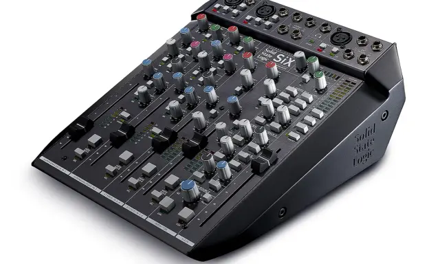 Table de mixage enregistrement multipiste Solid State Logic SIX, avec ses potentiomètres colorés et ses faders pour un contrôle précis du son.