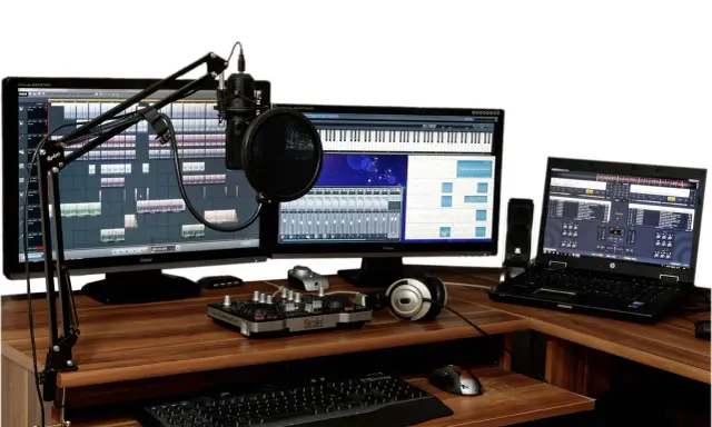 Postes de travail audio avec microphones, claviers, écrans affichant des logiciels de musique, et un ordinateur portable.