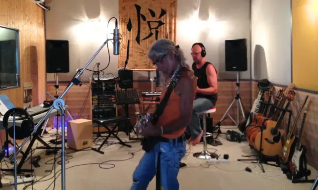 Un groupe enregistre dans un studio, prêt à injecter une touche de french touch musique. Guitares, claviers et micros sont prêts.