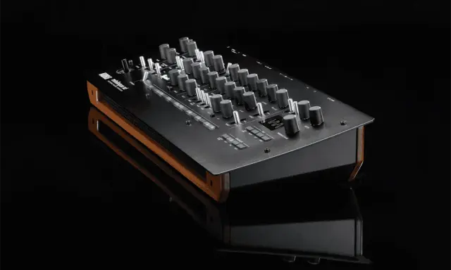 Synthétiseur Korg minilogue xd noir avec finitions bois, posé sur une surface réfléchissante.