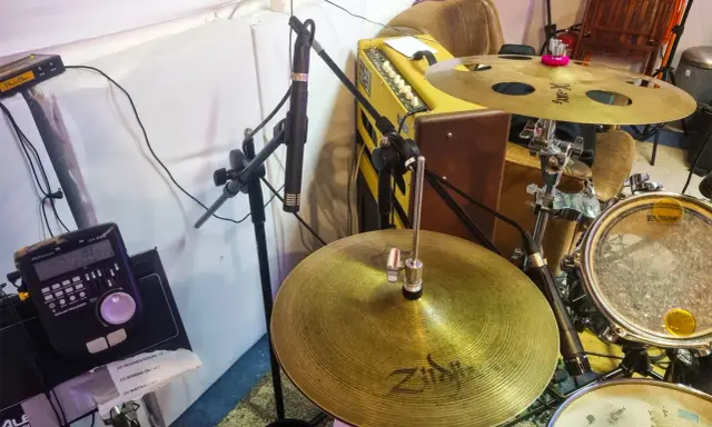 Un micro est positionné pour capter le son d'une batterie acoustique, prêt à enregistrer le rythme.