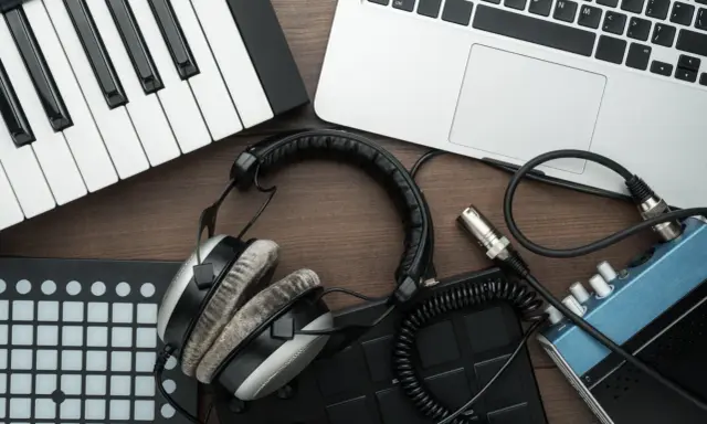 Clavier, casque, ordinateur portable et pads de batterie, idéal pour créer de la musique avec un logiciel beatmaking gratuit.