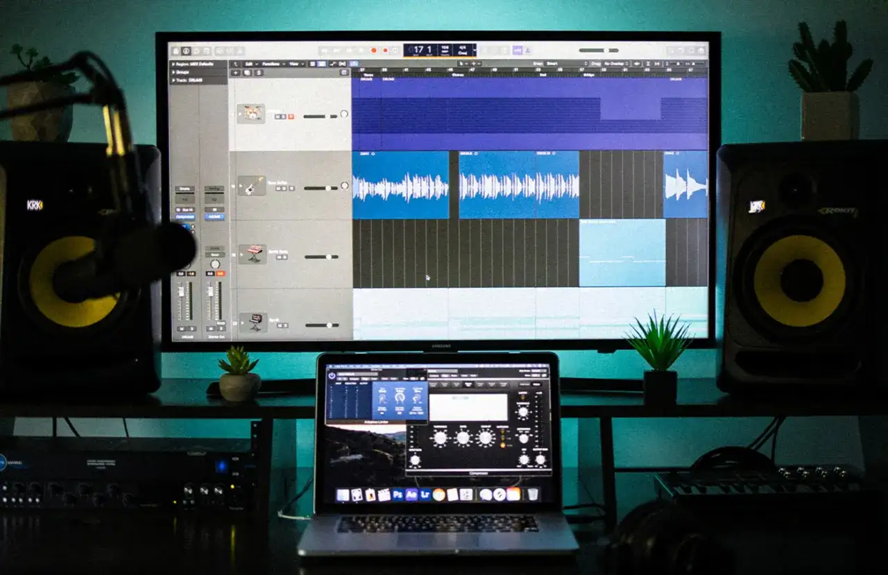 Studio d'enregistrement avec écran affichant un logiciel de musique, des enceintes et un microphone. Le logiciel de musique, qui ressemble à Cakewalk, est prêt pour la création.