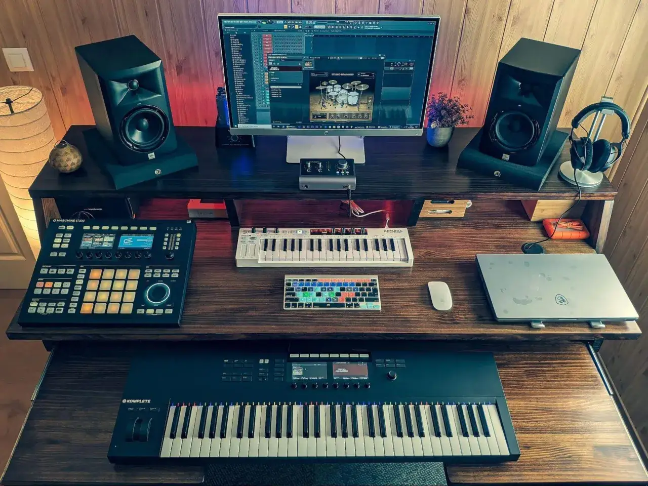 Studio de musique prêt à créer un son incroyable. Claviers, enceintes, ordinateur et contrôleurs sont alignés pour composer.