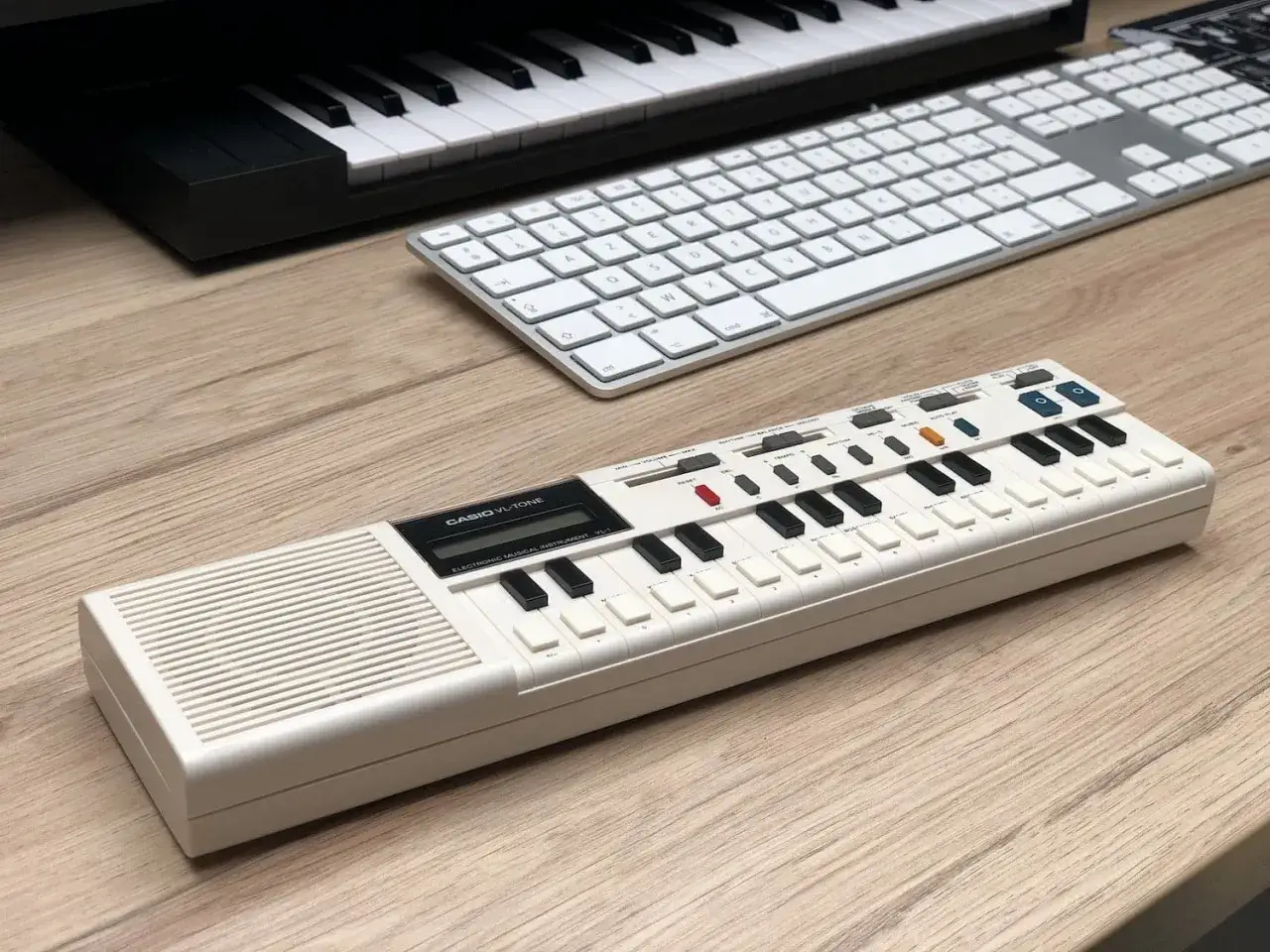 Clavier Casio VL-Tone, parfait pour un test oreille absolue sans connaître les notes. Un clavier blanc sur un bureau en bois.