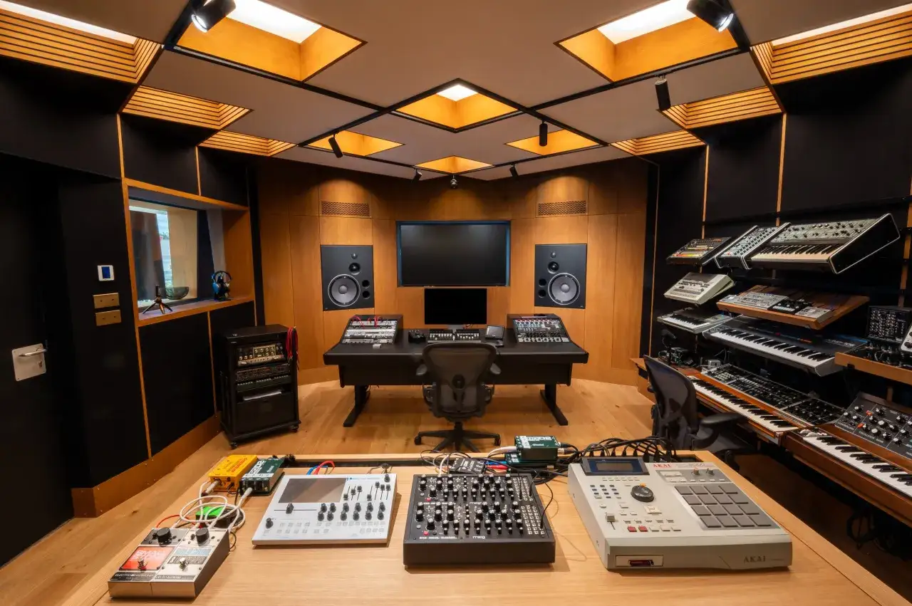 Studio d'enregistrement prêt à faire un EP, avec synthétiseurs, boîtes à rythmes et tables de mixage.