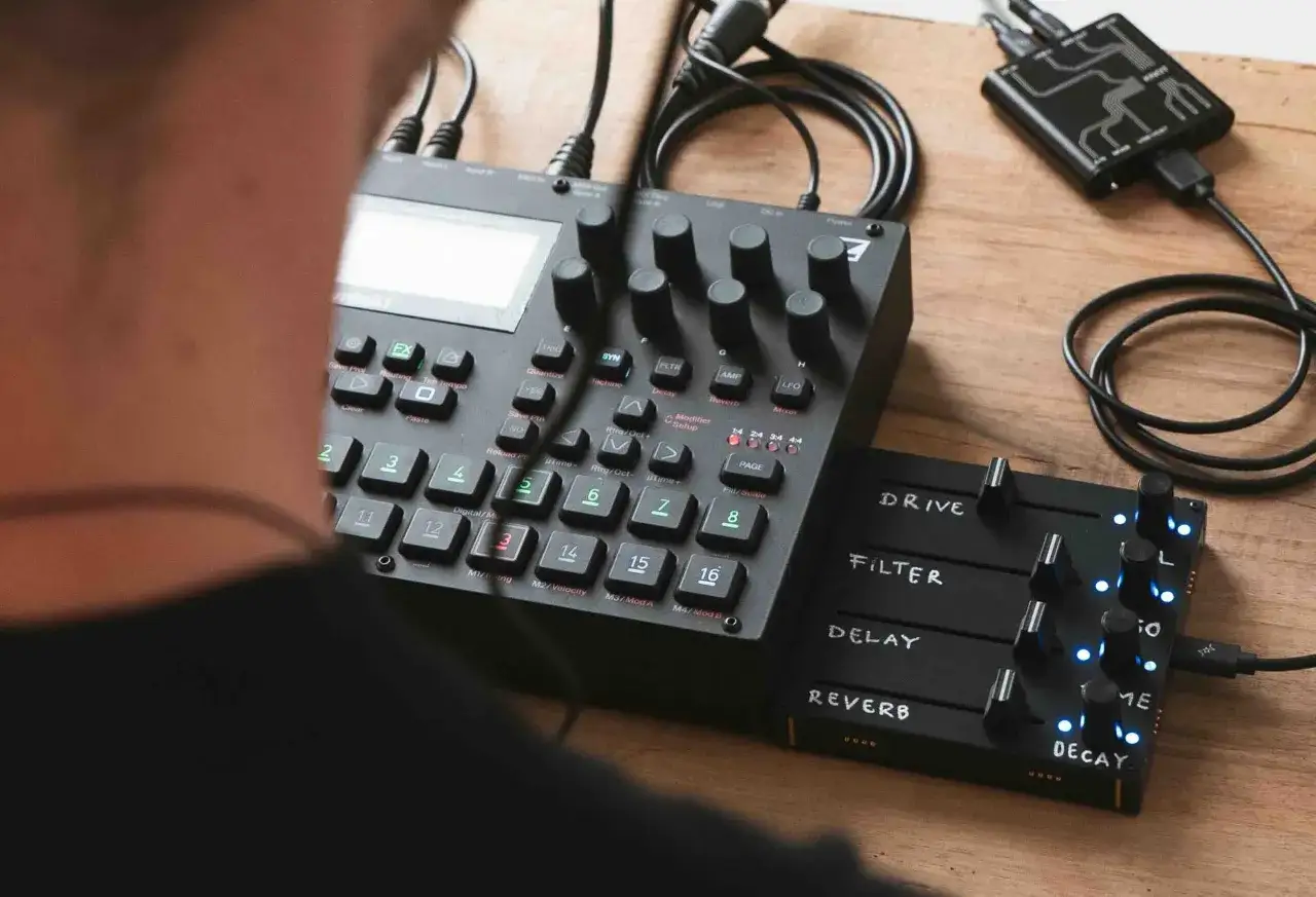 Un musicien manipule un Elektron Syntakt, explorant ses sons avec un module de contrôle externe.