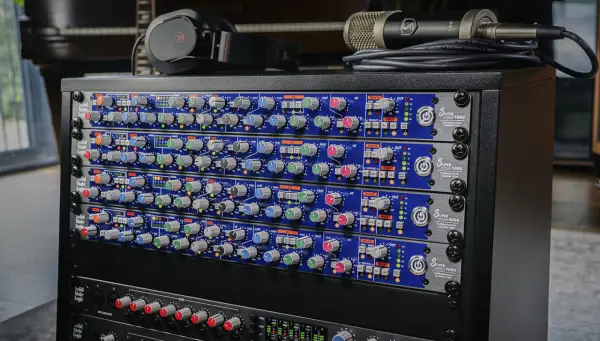 Rack de matériel audio avec plusieurs modules SSL Super 9000, un microphone et un casque.